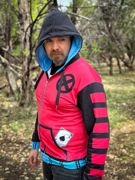 Man wearing Kinetic Gambler Zip-up Hoodie in a forest setting, showcasing its vibrant design and comic-inspired details.