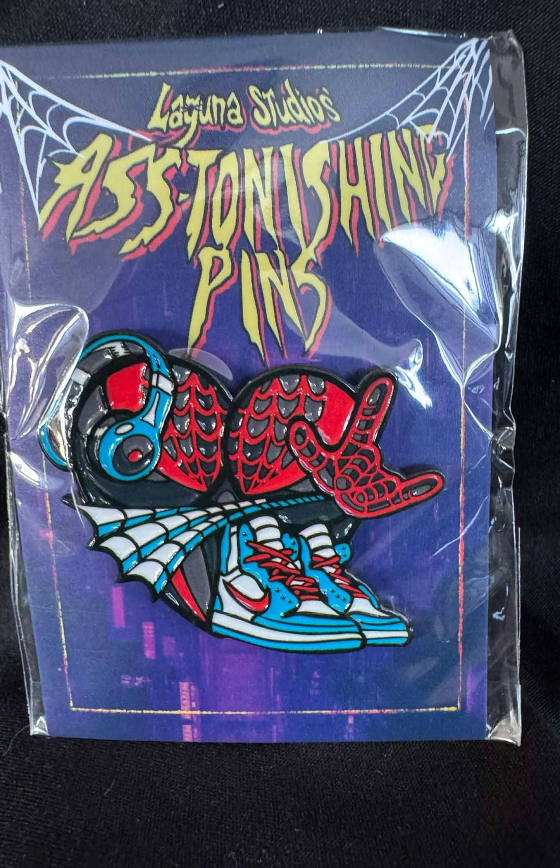 Kilometers ASS-tonishing Pin featuring vibrant comic book-inspired design by Laguna Studios.