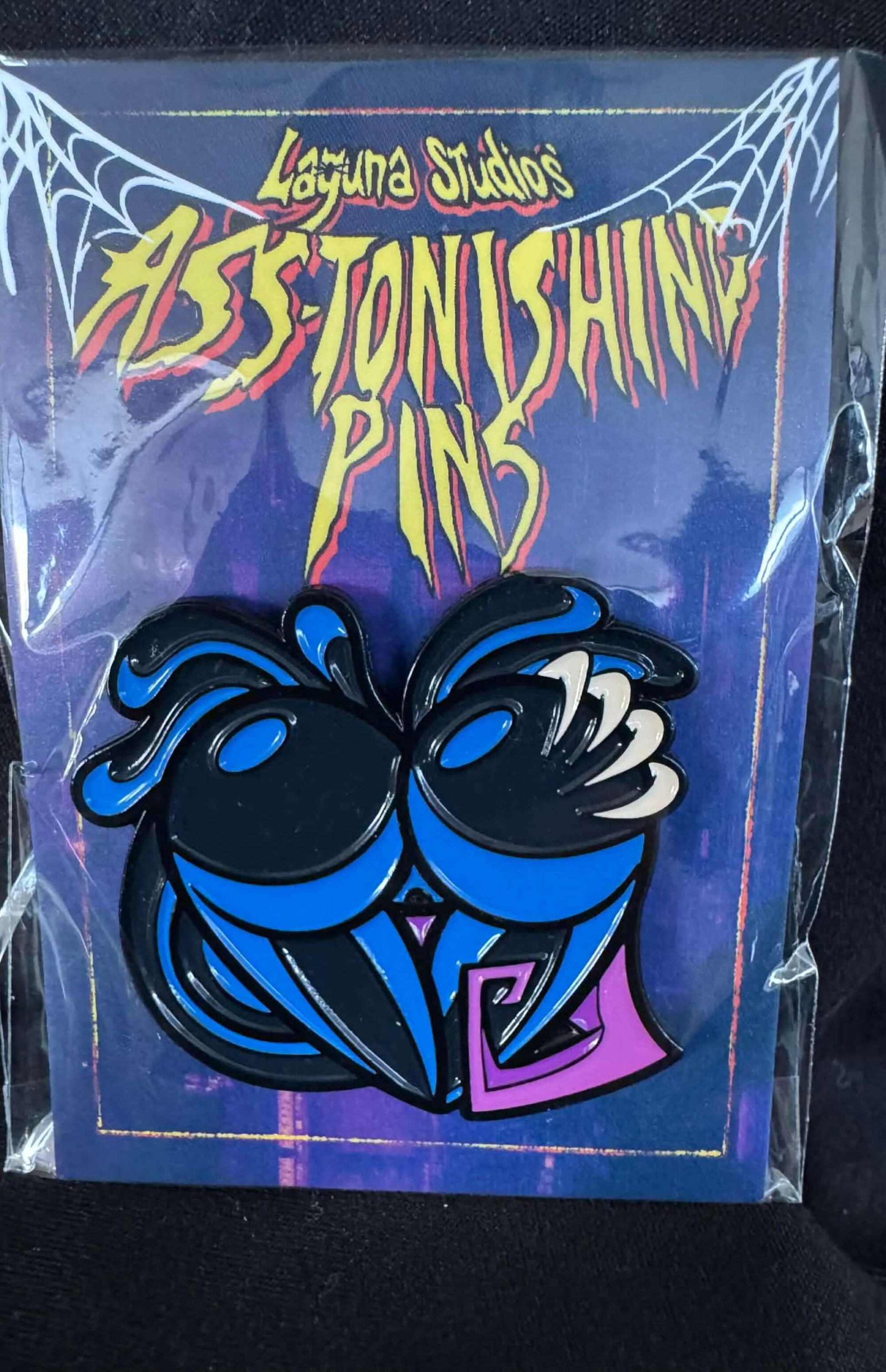 Oilyalien ASS-tonishing Pin from Laguna Studios, featuring a playful and dark comic book design.