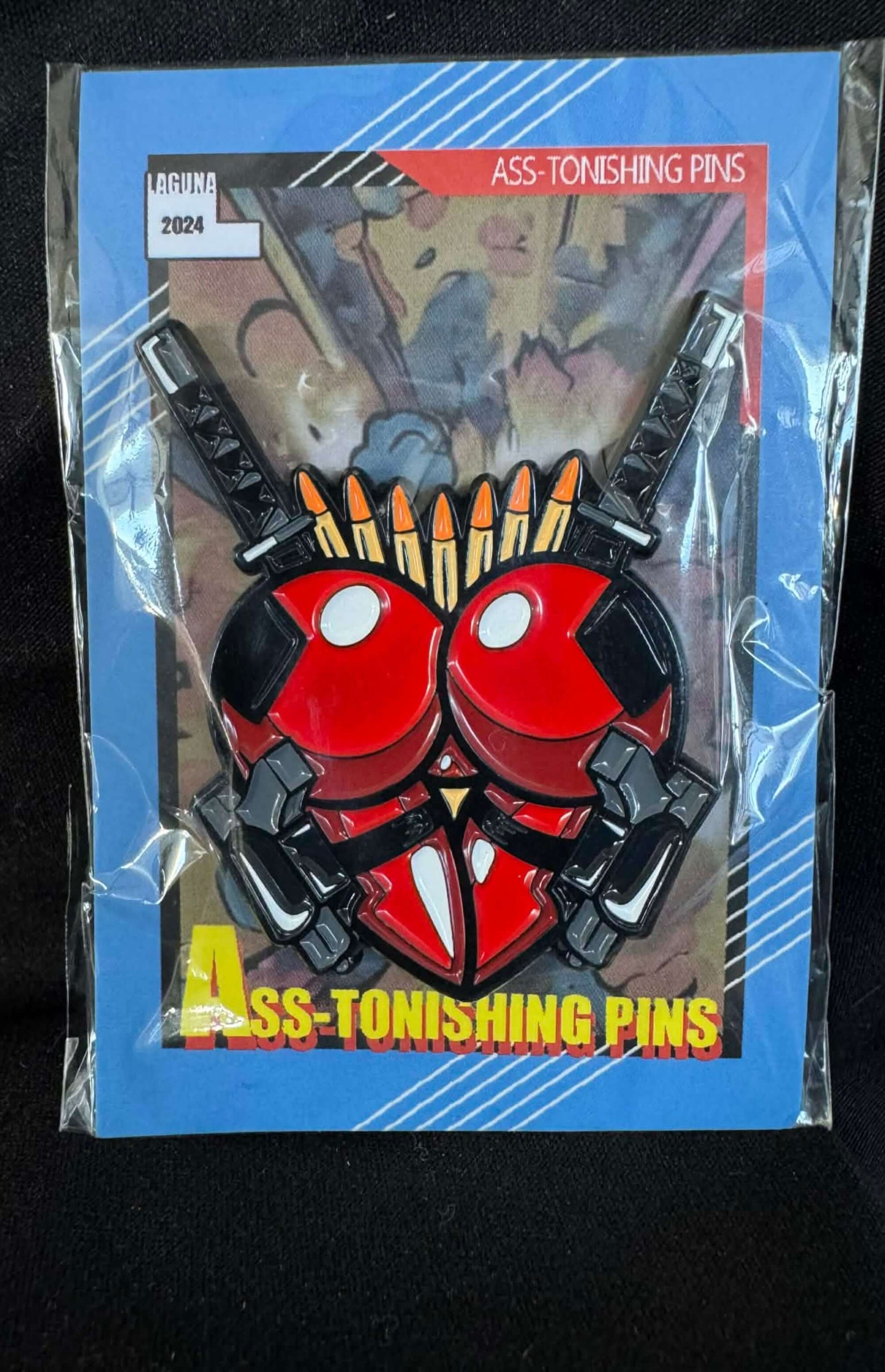 Ryan ASS-tonishing Pin packaging featuring bold red and black design with comic book style elements.