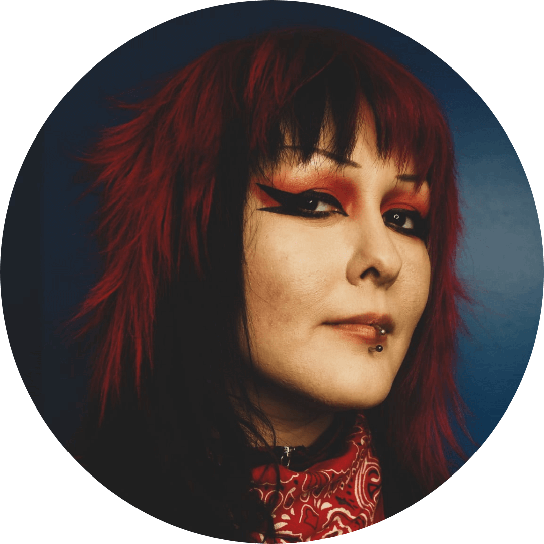 Stylish portrait of a woman with vibrant red hair and bold makeup, showcasing a unique and artistic look.
