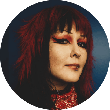 Stylish portrait of a woman with vibrant red hair and bold makeup, showcasing a unique and artistic look.