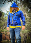 Man wearing a blue and yellow Monster Zip-up Hoodie in a forest, showcasing its unique comic book design.