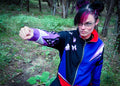 Model showcasing the Psychic Ninja Track Jacket in a forest, striking a confident pose with a determined look.